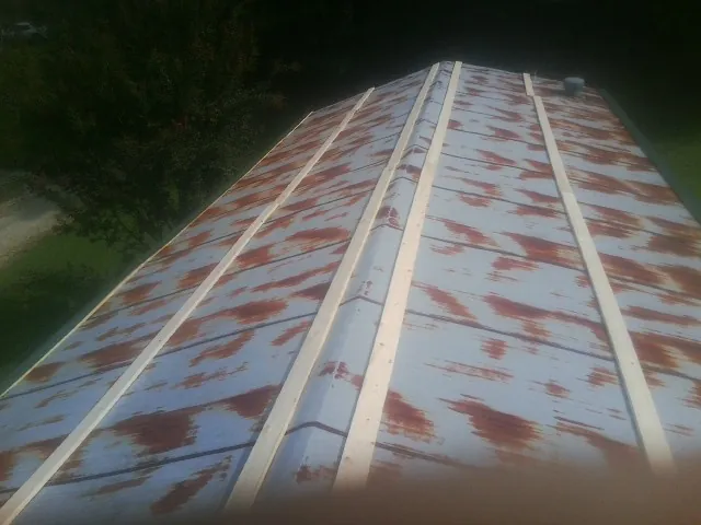 Rusted metal roof panels with new wood purlins before replacement — Storm Damage Roof Repair in Abie by Roofing Brothers